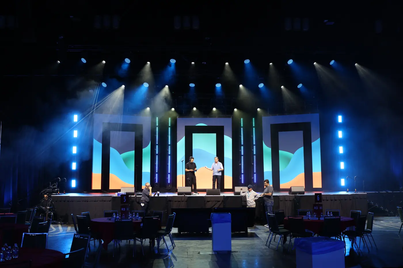 Stage with colorful LED wall columns and people on stage under show lighting