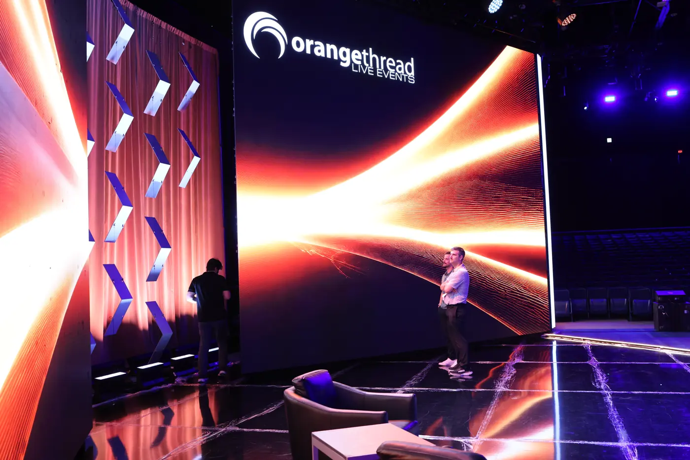 Orange Thread LIVE LED wall turning a corner behind a stage setup